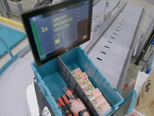 Person picking item out of robotic shuttle at the pick station