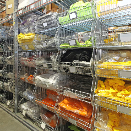 Metal storage shelves storing many types of colored shirts